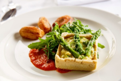 Quiche with asparagus on white plate