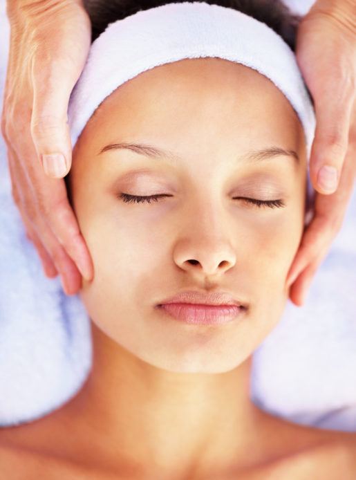 Woman enjoying a facial at a health club spa