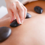 Woman enjoying a hot stone massage in a health club spa