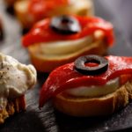 Canapes with red peppers and olives on a slate